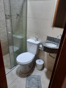 a bathroom with a toilet and a glass shower at Pousada Mãe Ternura Palace in Aparecida