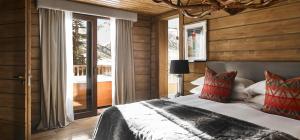 a bedroom with a bed and a large window at El Lodge, Ski & Spa in Sierra Nevada