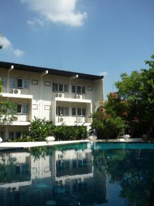 a building and a swimming pool in front of a building at Changpuak Hotel in Chiang Mai