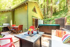 a backyard patio with a table and a refrigerator at Vino Velo Retreat! Redwoods! Hot Tub!! Fire Table!! BBQ!! Game Room!! Fast WiFi!! Dog Friendly!! in Guerneville