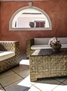 a patio with wicker furniture and a mirror at Basilicata Host To Host - SUNSHINE HOUSE - BORGO SAN BASILIO in Marina di Pisticci