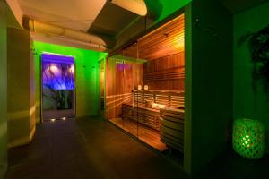 チェゼナーティコにあるHotel Vista Mare & Spaの緑と紫の照明が壁に付いたバスルーム