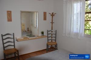 zwei Holzstühle in einem Zimmer mit Spiegel in der Unterkunft Diy House by A&D Properties in Porto Rafti
