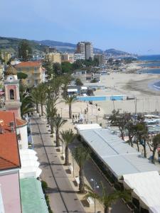 uma vista para uma praia com palmeiras e edifícios em Hotel Ideal em Arma di Taggia