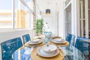 リスボンにあるGuesthouse Liberdade - 7 Bedroom Apartmentのダイニングルーム(テーブル、青い椅子付)