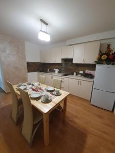 a kitchen with a wooden table with chairs and a refrigerator at Mrowca Noclegi Pokoje Gościnne in Gronków +40 photos