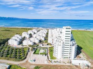 GhaziveranAphrodite Beachfront Resort Official的享有毗邻大海的白色公寓大楼的空中景致