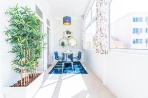 リスボンにあるGuesthouse Liberdade - 7 Bedroom Apartmentの廊下(テーブル、椅子、植物付)