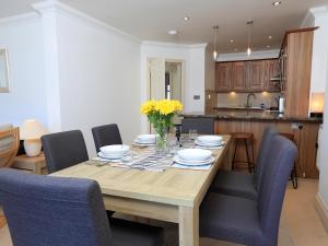 a dining room table with blue chairs and a kitchen at 2 Embankment House in Dartmouth +19 photos