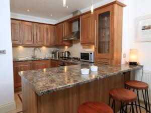 a kitchen with wooden cabinets and a granite counter top at 2 Embankment House in Dartmouth