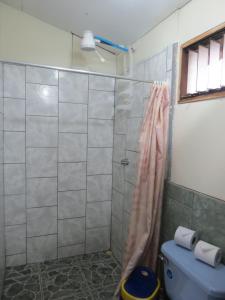 a bathroom with a shower and a blue toilet at Poponjoche Lodge Caño Negro in Caño Negro