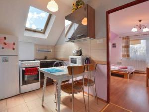 a kitchen with a table and some chairs in it at Agroturystyka Nad Bugiem Szuminka in Szuminka