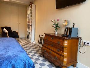a bedroom with a bed and a dresser with a tv on it at Prinsengracht Museum Bed and Breakfast in Amsterdam