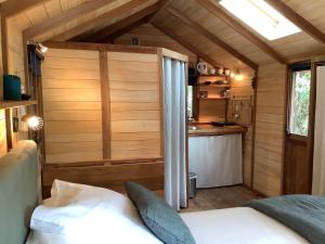 a bedroom of a tiny house with a bed and a kitchen at La Cabane d'Arbolateia piscine & SPA in Bidart