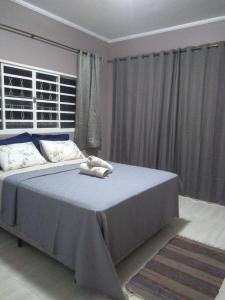a bedroom with a large bed with a blue blanket at casa temporada lua nova centro in Alto Paraíso de Goiás