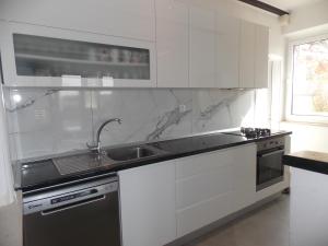a white kitchen with a sink and a stove at Perina Apartment - free parking in Dubrovnik