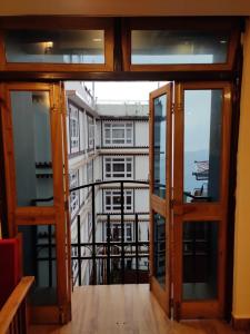 an open glass door with a view of a building at Hotel The Narayani Continental in Gangtok