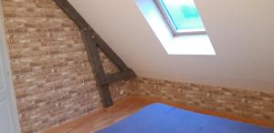 a room with a brick wall and a skylight at La maison de Mathilde in Saint-Jean-de-la-Motte