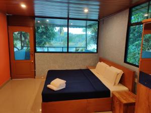 a bedroom with a bed in a room with windows at 7 Heaven Resorts in Ambalavayal