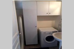 a small bathroom with a washing machine and a sink at Pigeon House Ornos Beach in Mikonos +21 photos
