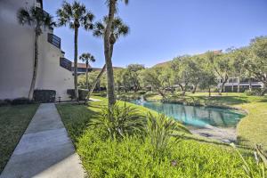 ein Haus mit einem Pool in einem Garten mit Palmen in der Unterkunft Sunny Siesta Key Condo with Beach Access and Pool! in Sarasota