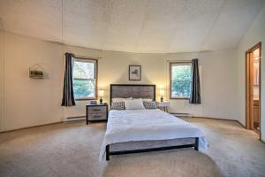 a large bedroom with a bed and two windows at Stylish Mountain Escape with Hot Tub, 3 Miles to Ski in Windham