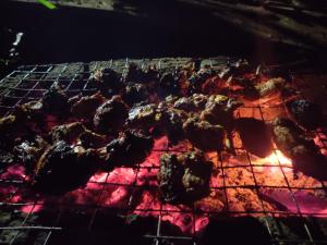 a bunch of meat cooking on a grill at 7 Heaven Resorts in Ambalavayal