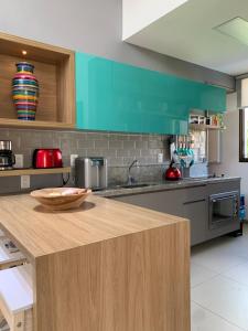 a kitchen with green cabinets and a wooden counter top at Oka Muro Alto in Porto De Galinhas