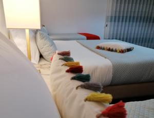 2 camas con almohadas coloridas juntas en Residencial Marques, en Cabaços