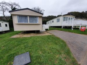 a small house in a yard with a driveway at 3 Bedroom Caravan, Sleeps 8, at Parkdean Newquay Holiday Park in Newquay
