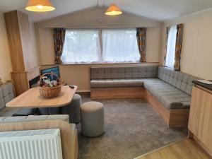 a living room with a couch and a table at 3 Bedroom Caravan, Sleeps 8, at Parkdean Newquay Holiday Park in Newquay