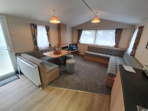 a living room with a couch and a table at 3 Bedroom Caravan, Sleeps 8, at Parkdean Newquay Holiday Park in Newquay +48 photos