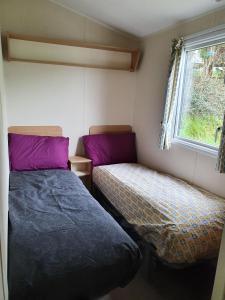 Llit o llits en una habitació de Cozy 3 bedroom Caravan, Sleeps 8, at Parkdean Newquay Holiday Park