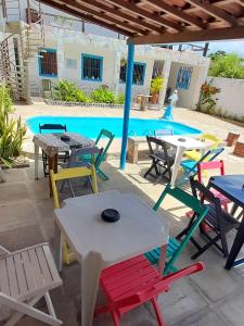 a group of tables and chairs in front of a pool at Ap05-A 50 Metros da Praia Flats Mobiliados para 6 Pessoas in Paulista
