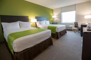 a hotel room with two beds and a window at Holiday Inn Express Managua, an IHG Hotel in Managua