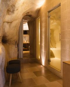 a room with a rock wall and a chair at La Corte Dei Pastori Luxury in Matera