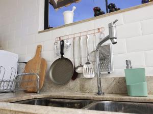 fregadero de cocina con utensilios colgado en la pared en Casa Corazul, en Arraial do Cabo 87 fotos más