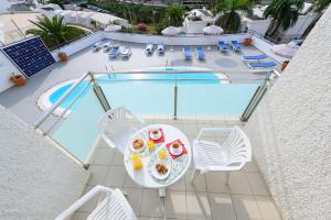 an overhead view of a table and chairs next to a swimming pool at Marianela Apartment in Puerto Rico de Gran Canaria
