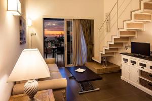 a living room with a staircase and a couch and a lamp at Tenuta Del Poggio Antico in Ischia