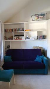 ein blaues Sofa im Wohnzimmer mit Bücherregalen in der Unterkunft Résidence azur sancy in Le Mont-Dore