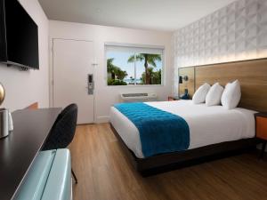 a hotel room with a bed and a desk at Motel 6-Santa Barbara, CA - Beach in Santa Barbara