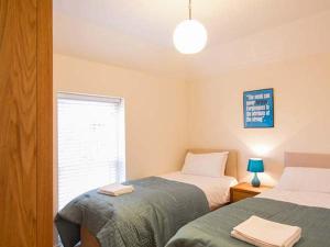 a bedroom with two beds and a window at Beechwood Cottage in Middlesbrough