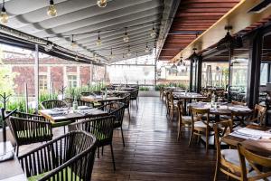a restaurant with wooden tables and chairs and windows at Domingo Santo Hotel Boutique in Mexico City