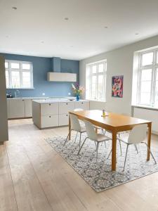 eine Küche mit einem Tisch und Stühlen im Zimmer in der Unterkunft aday - 4 Bedroom - Modern Living Apartment - Aalborg in Aalborg