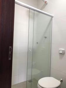 a bathroom with a glass shower with a toilet at Hotel Bee's Sorriso in Sorriso