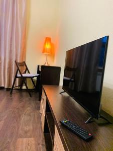 een flatscreen-tv bovenop een houten kast bij Комфорт-апартаменти біля Хрещатика, безконтактне заселення 24х7 in Kiev