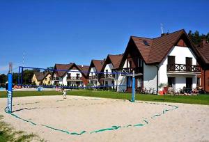 a child standing on a volley ball court on a beach at Apartament Łeba in Żarnowska