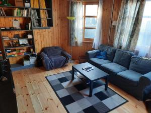 a living room with a blue couch and a table at Faház Hejce in Hejce