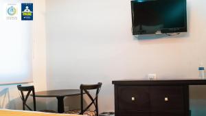 Pokój ze stołem i telewizorem na ścianie w obiekcie Hotel Maioris Kumate Culiacán w mieście Culiacán