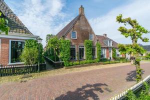 una casa con una entrada de ladrillo delante de ella en TERP WONING bij Schiermonnikoog "Op de Terp" Noordoost Friesland, en Ee